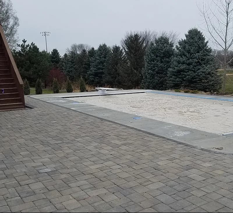 A pool in the fall with the pool cover on.