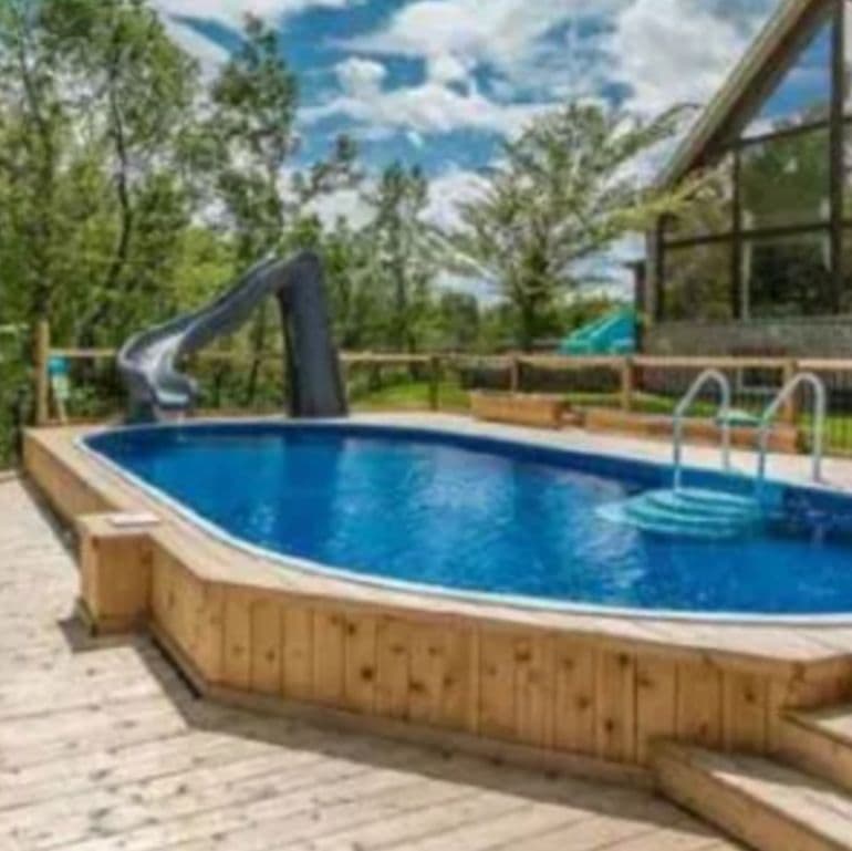 Above-ground pool on a wooden deck outside a A-frame home
